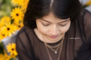 Senior Girl takes photos in yellow summer flowers in Pittsburgh, PA