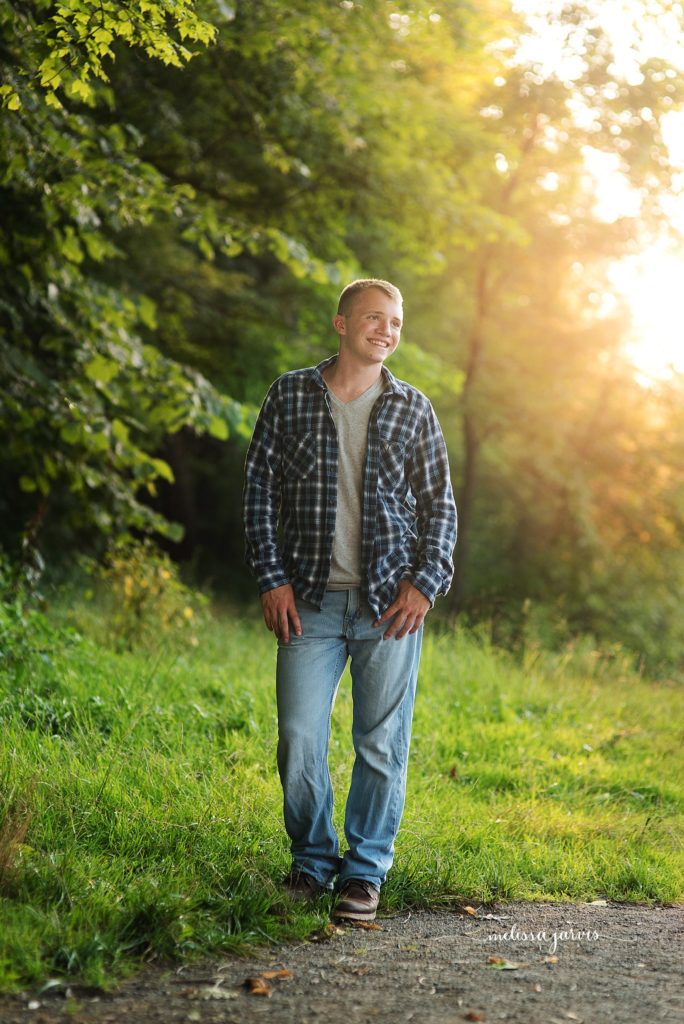 senior boy in plaid stands at sunset senior portraits in Bethel Park PA